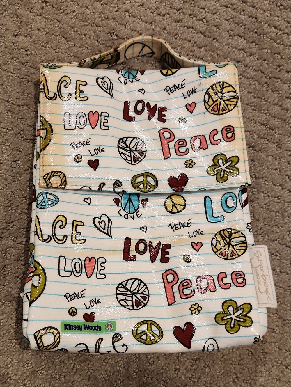 This SugarBooger brand lunch bag features a vibrant "Peace & Love" doodle patter